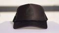 Black cap with Okley logo on a white surface
